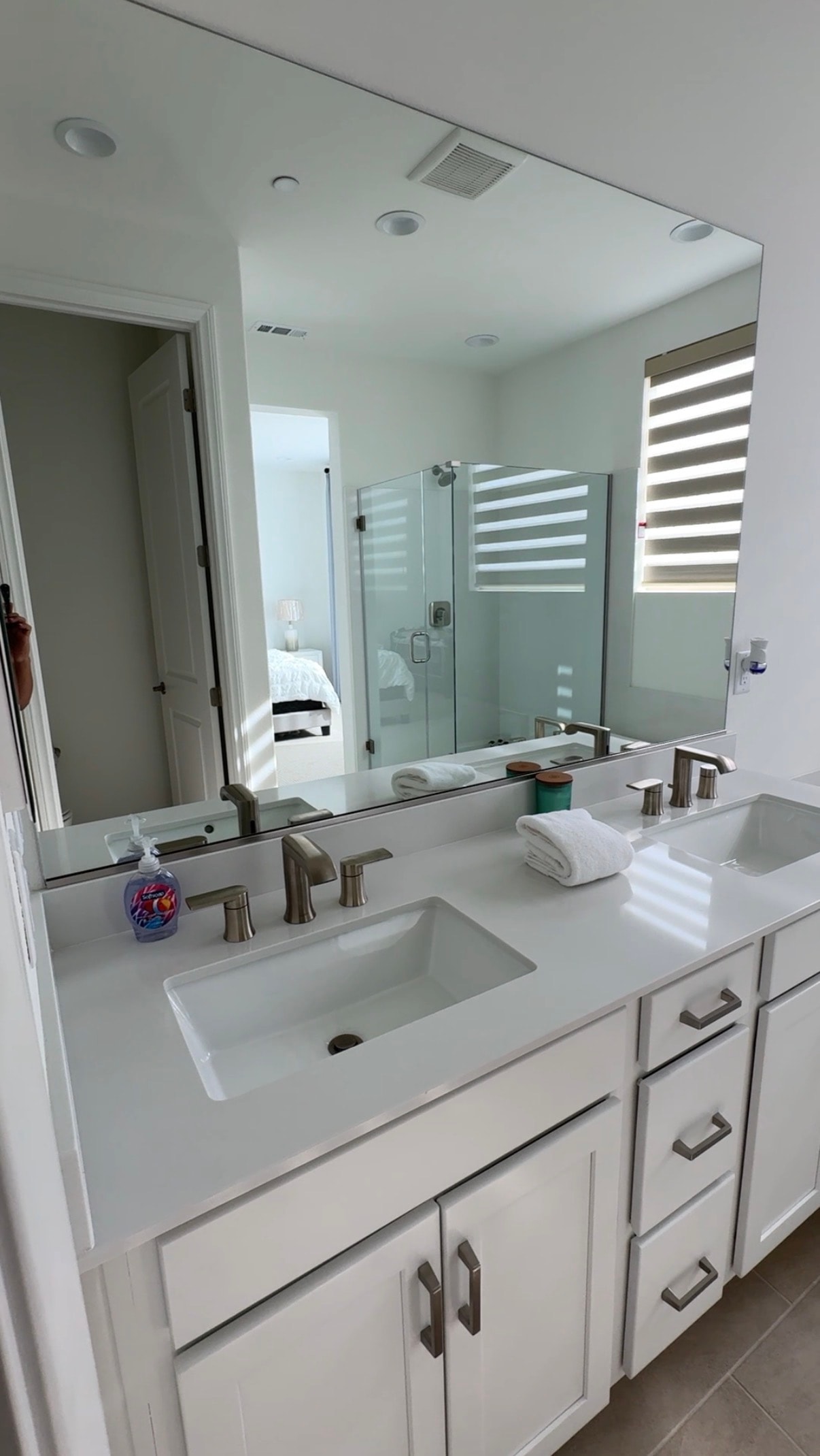 Airbnb master bathroom with dual vanity and large mirror